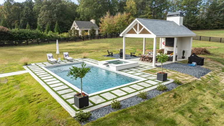 A large swimming pool with a gazebo in the backyard of a house.