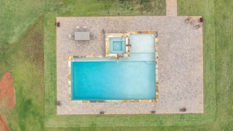 An aerial view of a large swimming pool surrounded by grass.