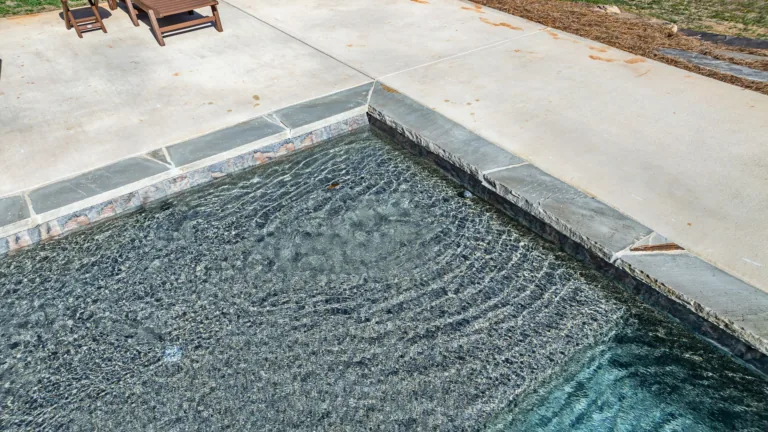 A swimming pool with chairs sitting on the side of it.