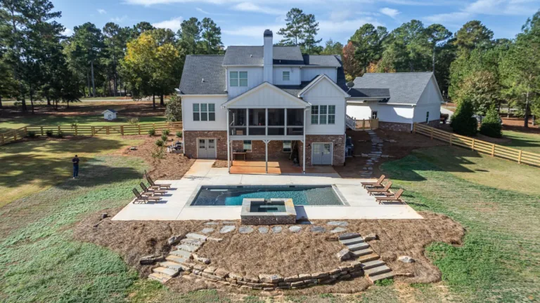 An aerial view of a house with a large pool in the backyard