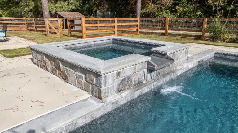 A swimming pool with a hot tub in the middle of it.