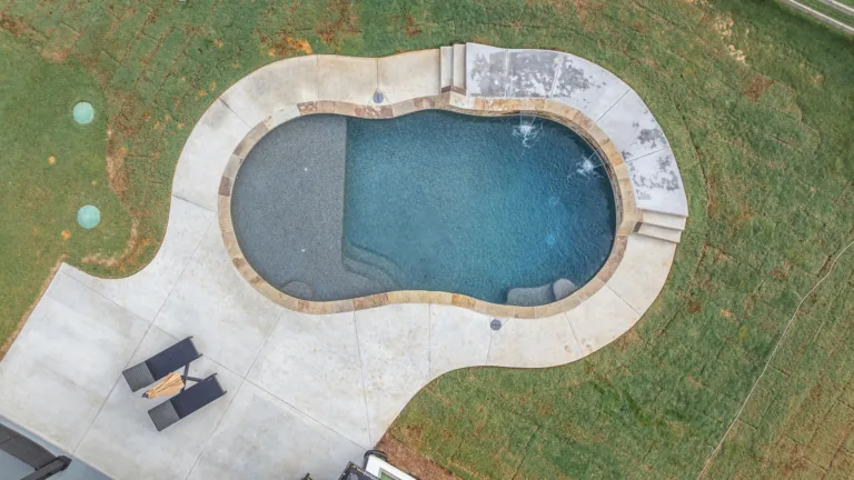An aerial view of a large swimming pool in a backyard.