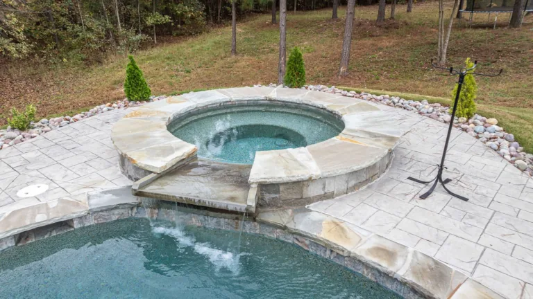 A swimming pool with a hot tub in the middle of it.